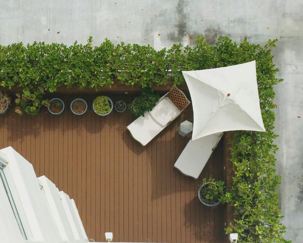 photo d'une terrasse prise de haut montrant des haies et des transats