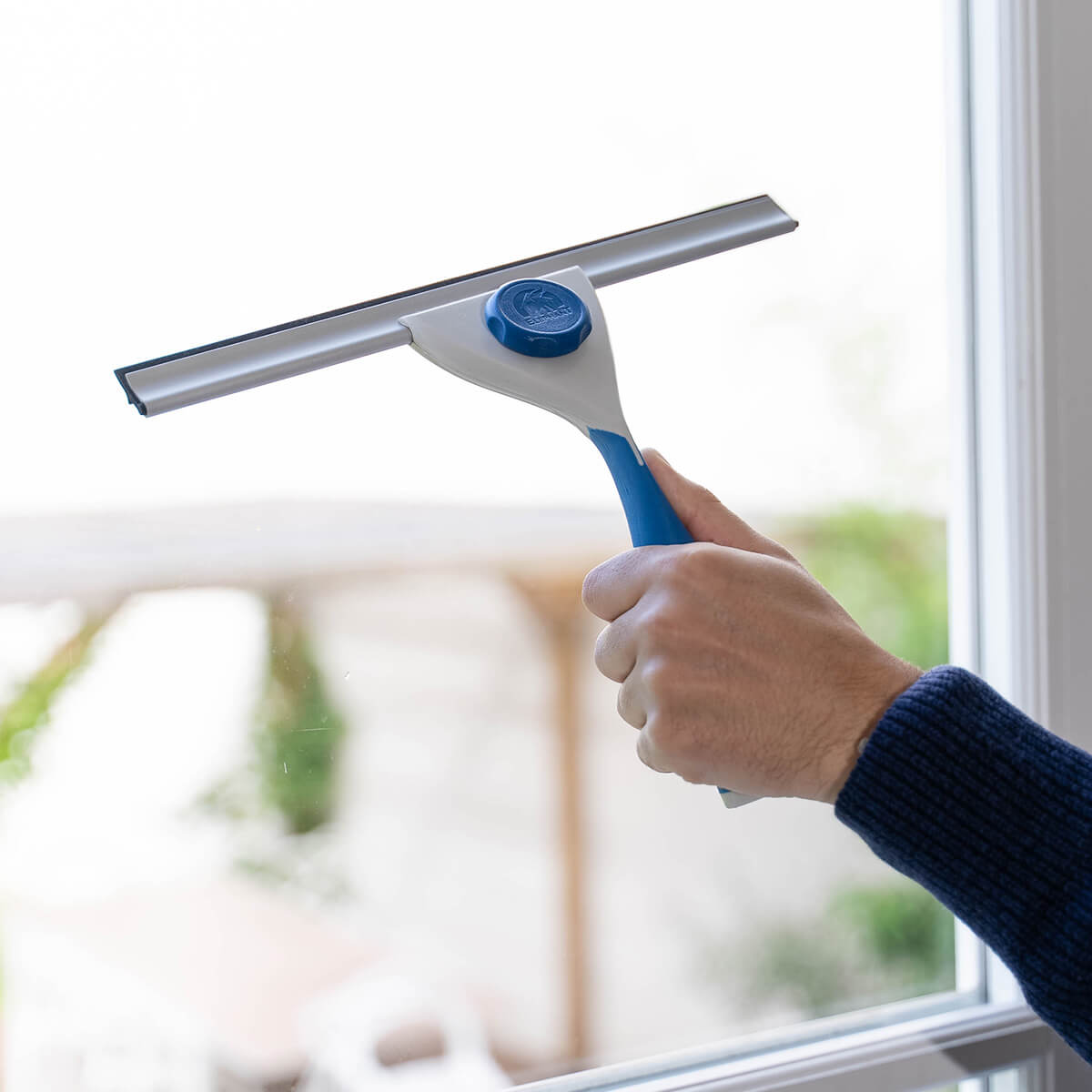 Nettoyer sa fenêtre de salle de bain avec une raclette