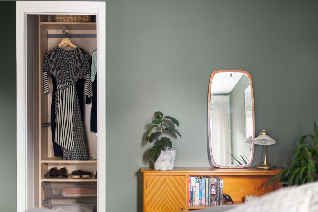Placard ouvert et meuble de chambre avec miroir, illustrant un intérieur rangé pour le ménage de printemps